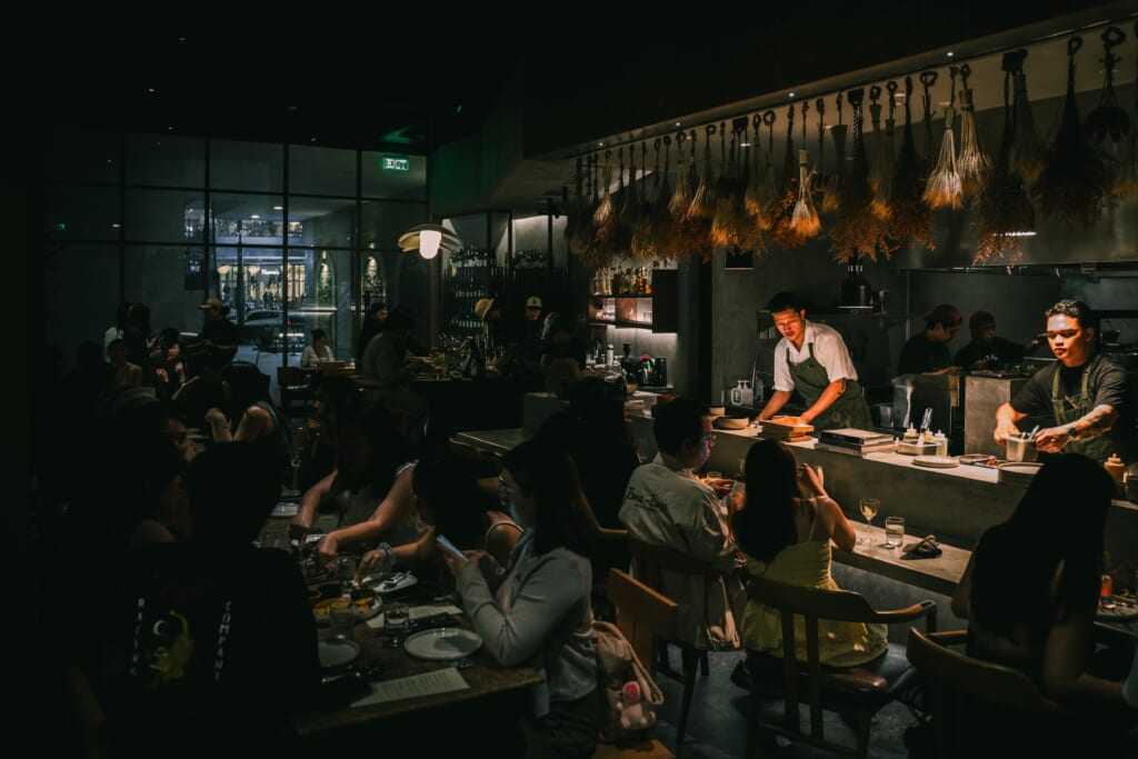 Chefs at Los Tacos MNL pressing tortillas in the open kitchen